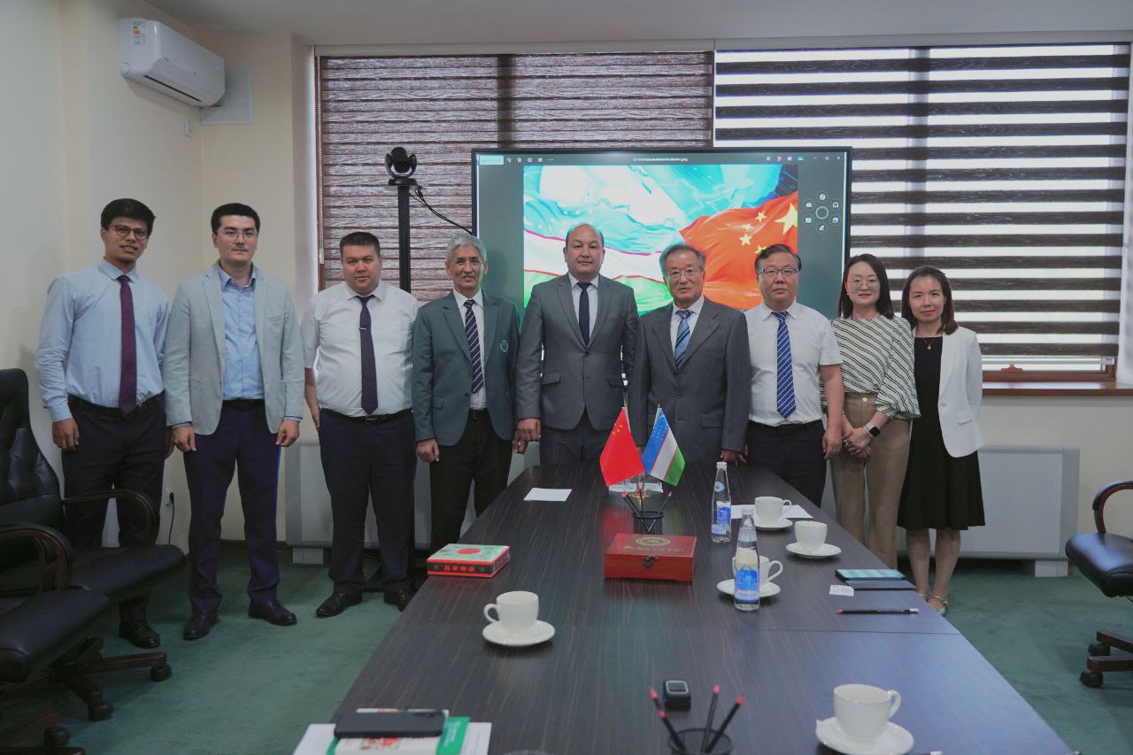 Uzbek and Chinese delegation meeting beneath both national flags