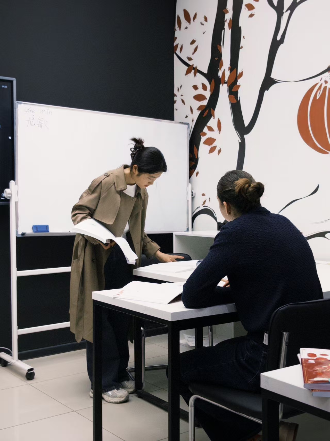 Faculty member working with a student in a classroom